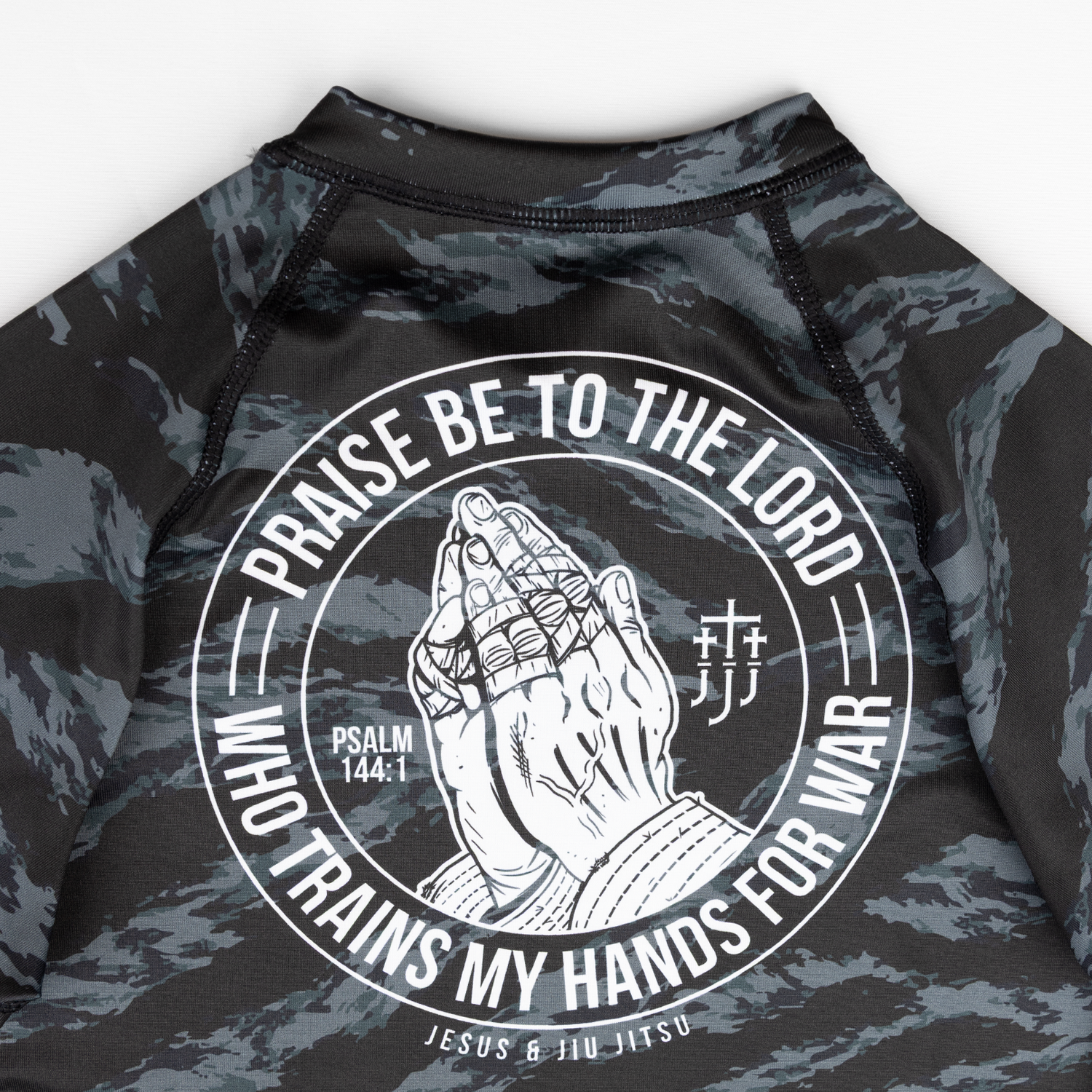 Closeup of praying hands graphic on back of ladies camo rashguard