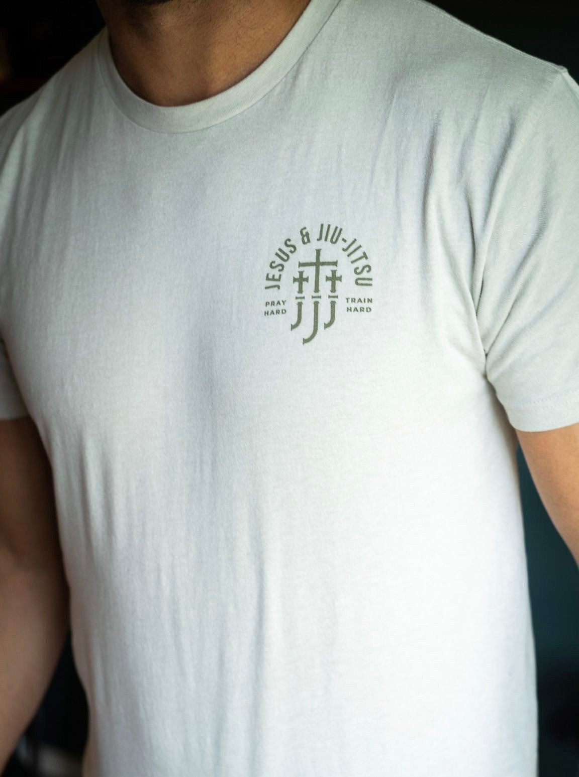 Man in sand tee with JJJ logo on left chest