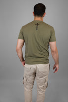 rear view of man wearing green tee with black cross