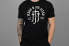 Man wearing a black t-shirt with white "JESUS & JIU-JITSU" text and logo on a gray background