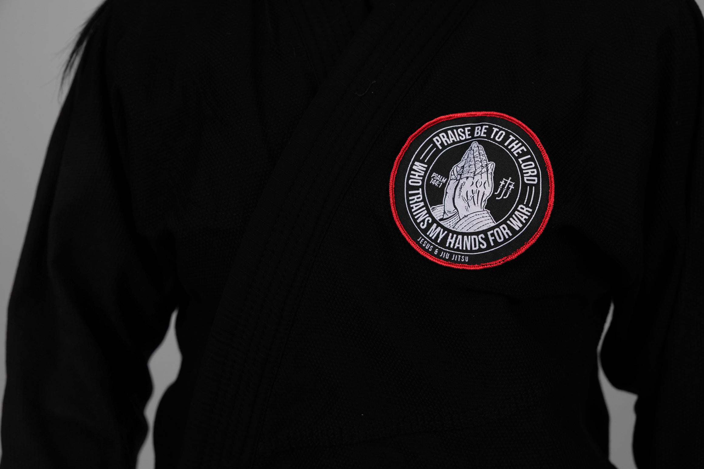 4in Patch with praying hands design and "PRAISE BE TO THE LORD WHO TRAINS MY HANDS FOR WAR" text on a black gi
