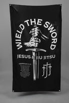Black flag with hands holding sword graphic with text "WIELD THE SWORD JESUS & JIU JITSU"