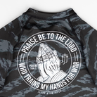 Closeup of praying hands graphic on back of ladies camo rashguard