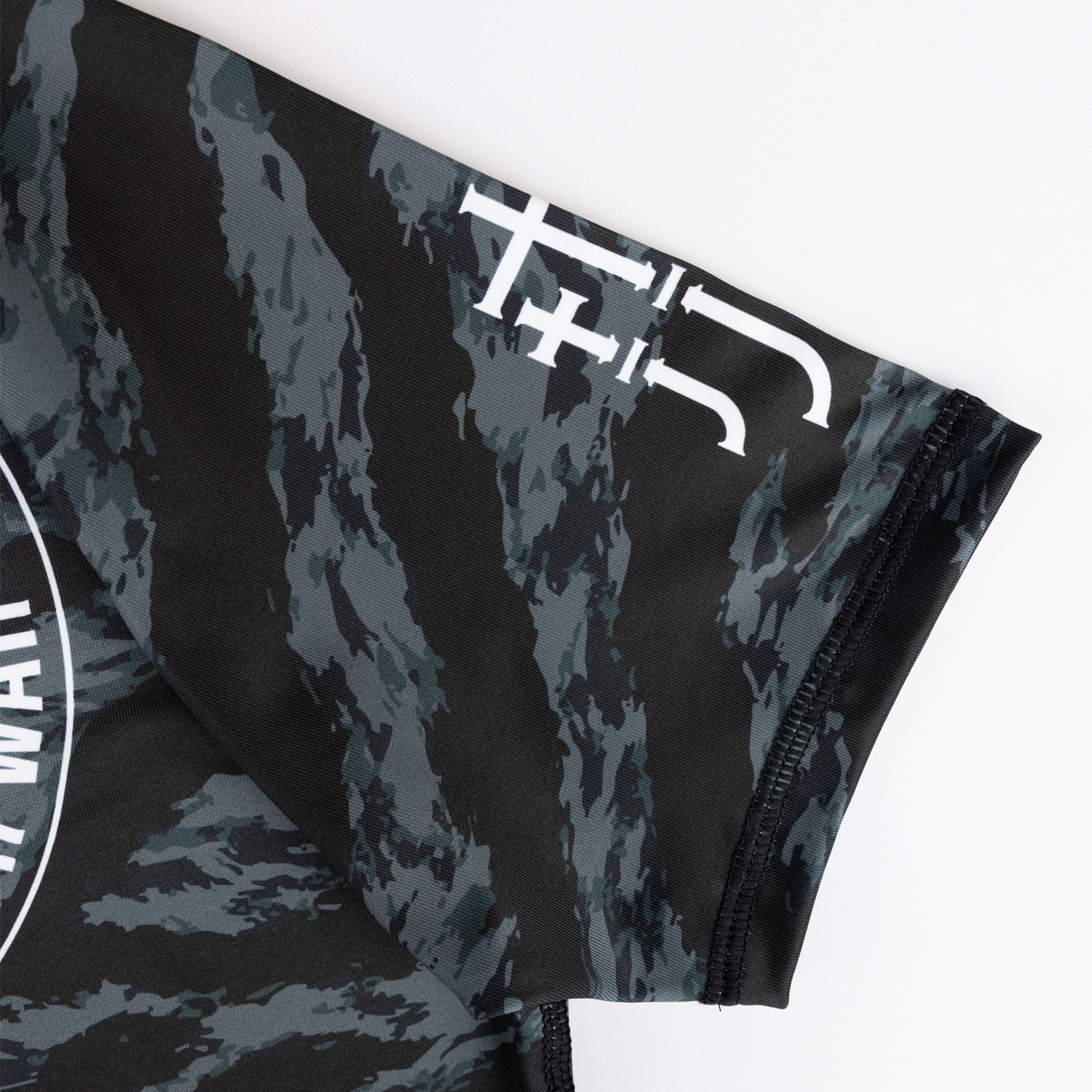 closeup of JJJ logo on sleeve of ladies camo rashguard