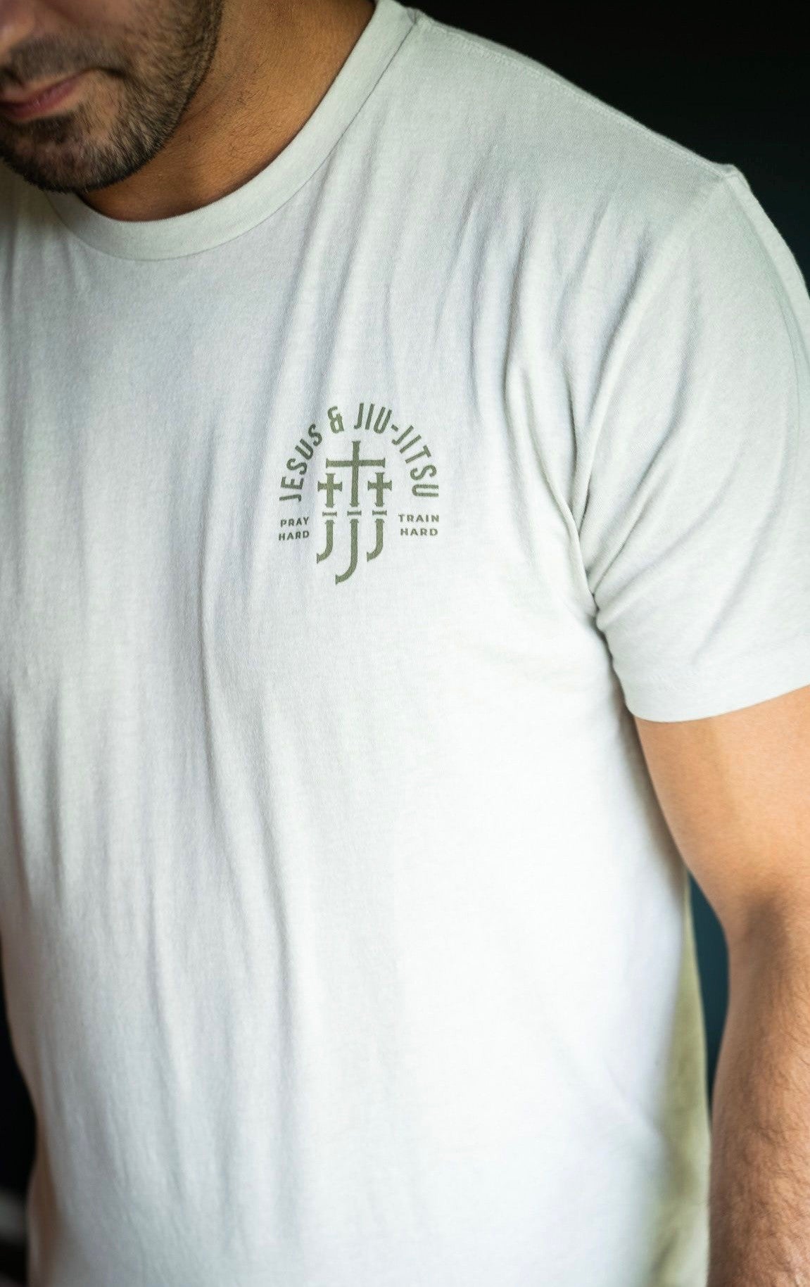 Man in sand tee with JJJ logo on left chest