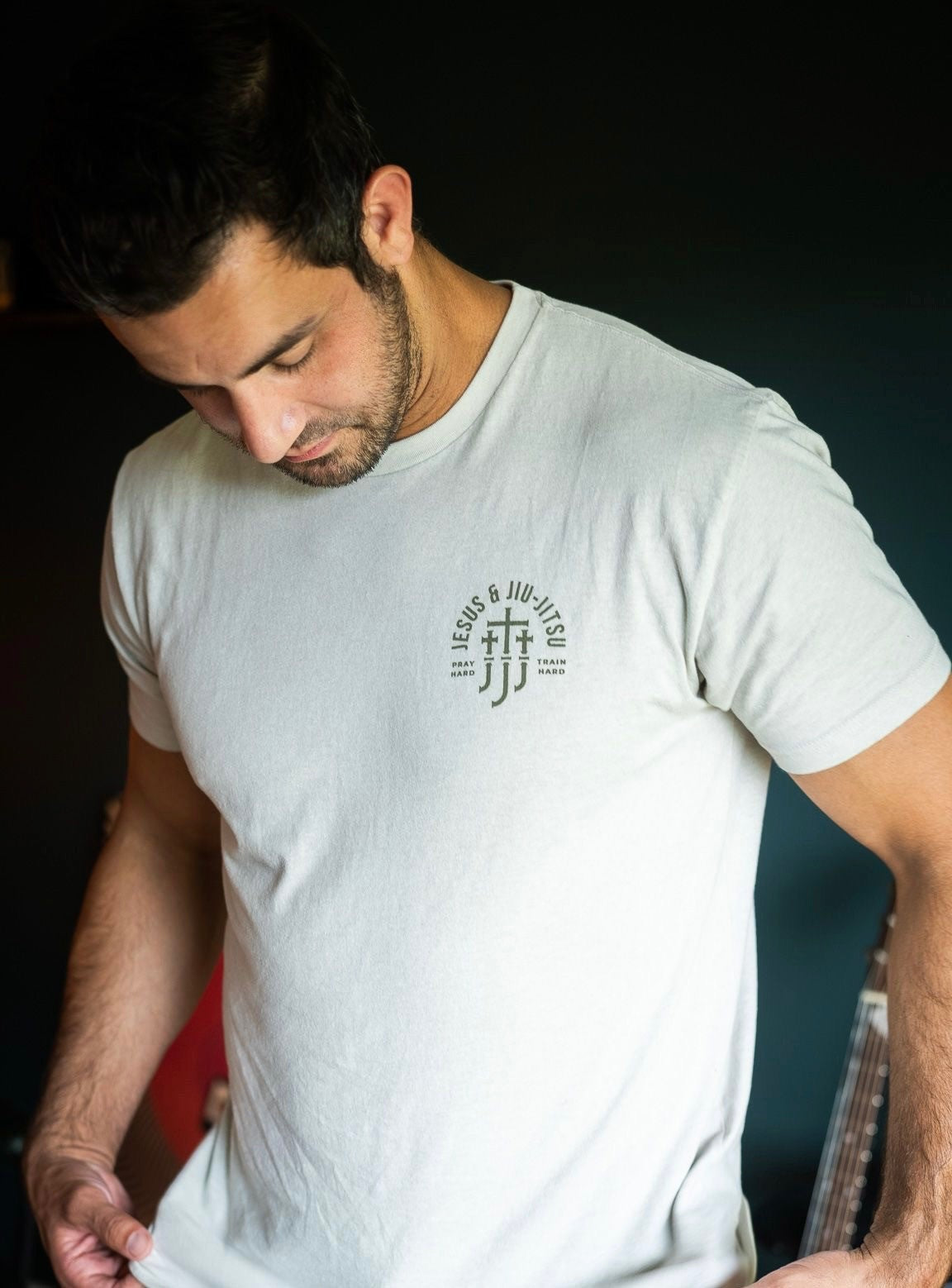 Man in sand tee with JJJ logo on left chest